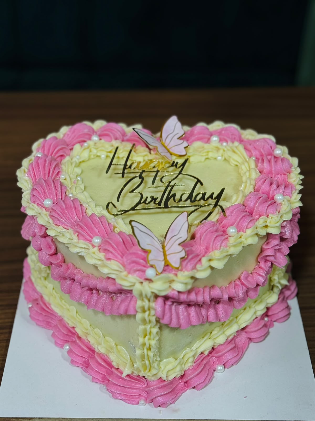 Gâteau cœur rose et blanc avec papillons