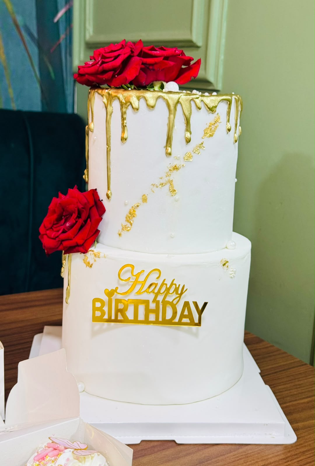 Gâteau d'anniversaire blanc à deux étages et roses rouges